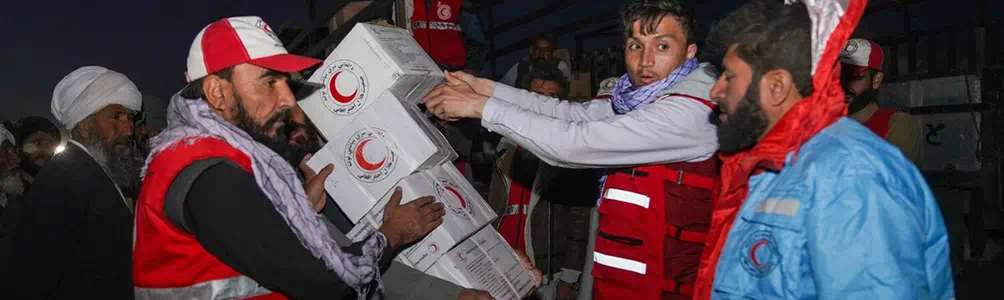 Red Crescent worker delivering boxes to people in Afghanistan
