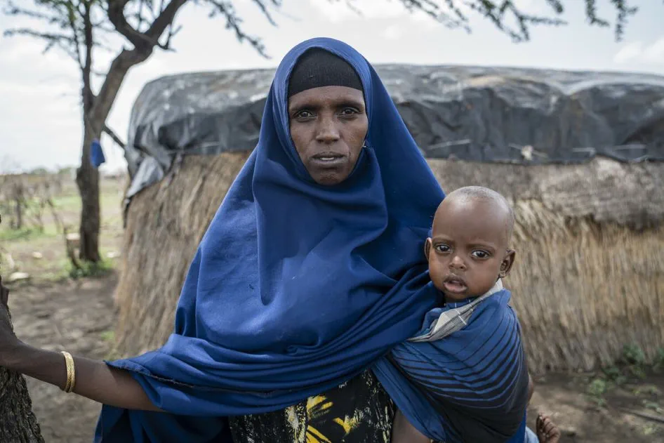 Kuresh with her son, one-year-old, outside their makeshift home, south of Babile.