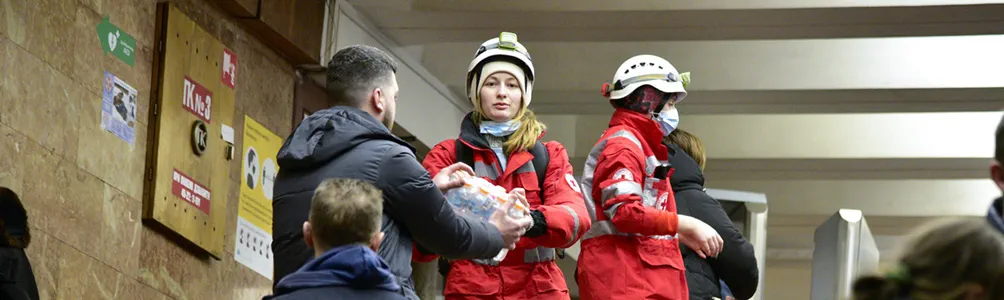 Red Cross volunteers hand out donations to people in crisis