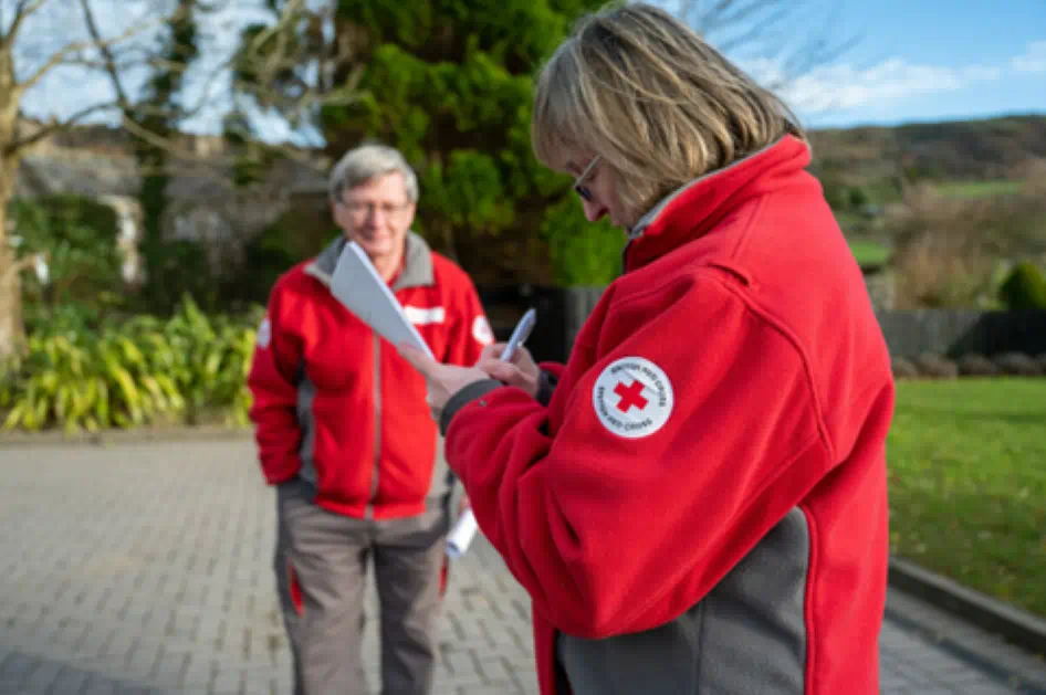 Red cross volunteers taking not on how to assist people.