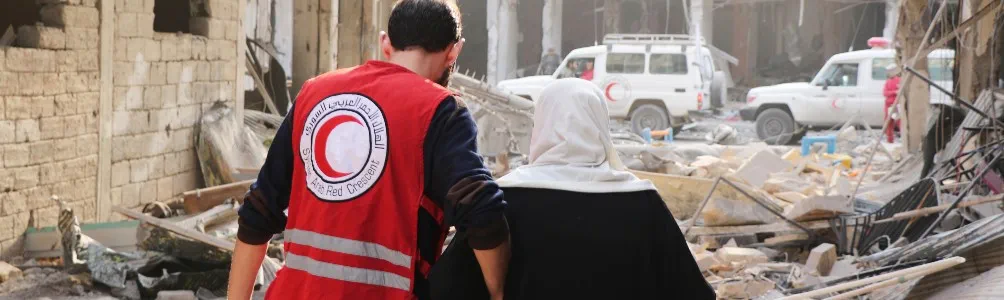 Red Crescent worker assisting Syrian woman