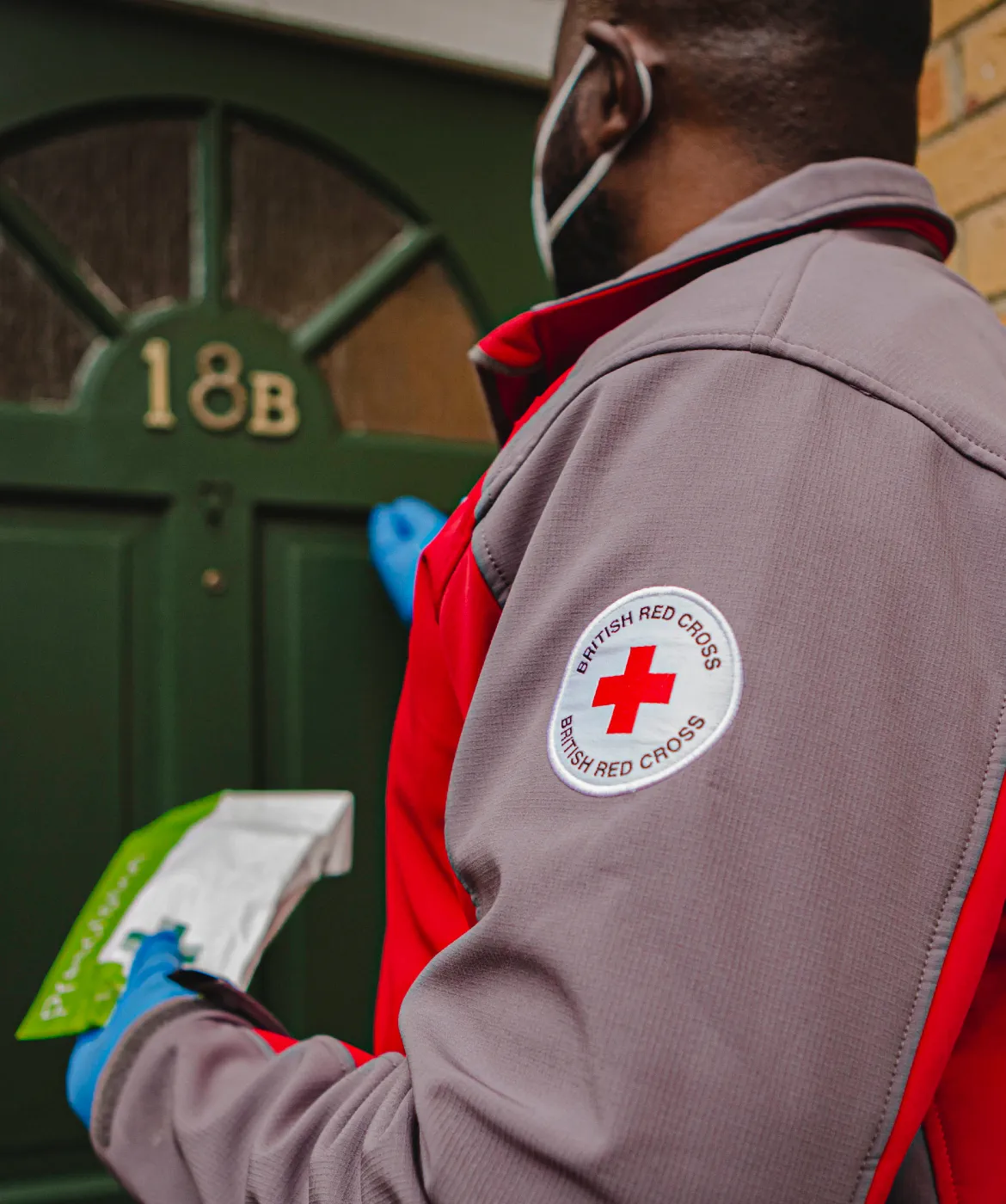 Emergency Response volunteer, Emmanuel, knocking on the door to deliver a prescription