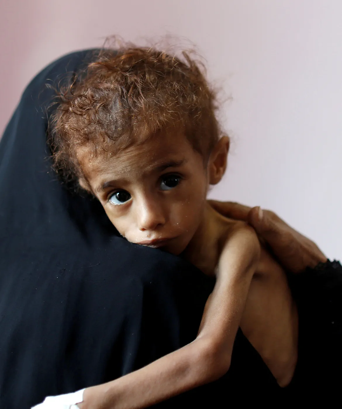 Young child in Yemen being held by mother